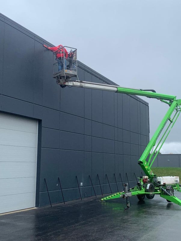 Installer-on-lift-installing-Lind-Banner-Frame-Classic-framing-kit-for-SEA-Limited Are One-Man Wallscape Banner Installations Possible?