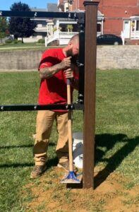 Lind-SignSpring-worker-patting-dirt-around-sign-stand-post-197x300 No Surface? No Problem! Lind Offers Free Standing Signage!