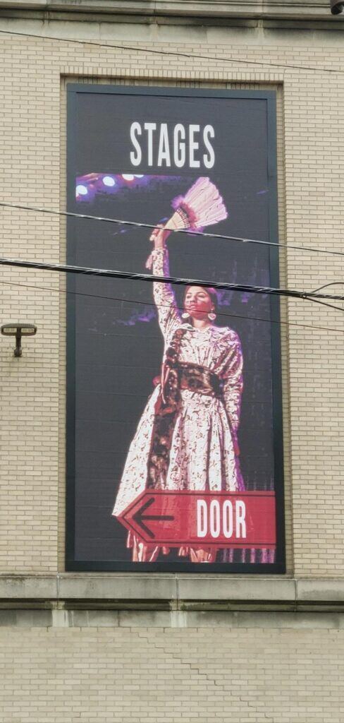Picture-of-a-women-dressed-up-on-stage-488x1024 Lind BannerFrame CLASSIC: Custom Banner Signs for Your Aging Brick Wall