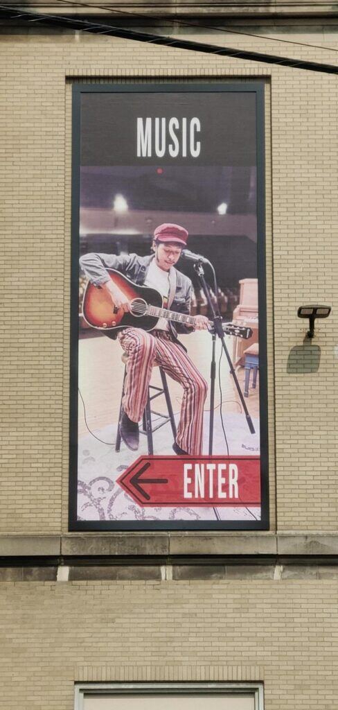 Poster-of-boy-playing-gutair-on-stage-488x1024 Lind BannerFrame CLASSIC: Custom Banner Signs for Your Aging Brick Wall