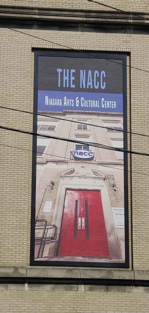 Poster-of-the-NACC-Niagara-Arts-and-Cultural-Center-488x1024 Lind BannerFrame CLASSIC: Custom Banner Signs for Your Aging Brick Wall