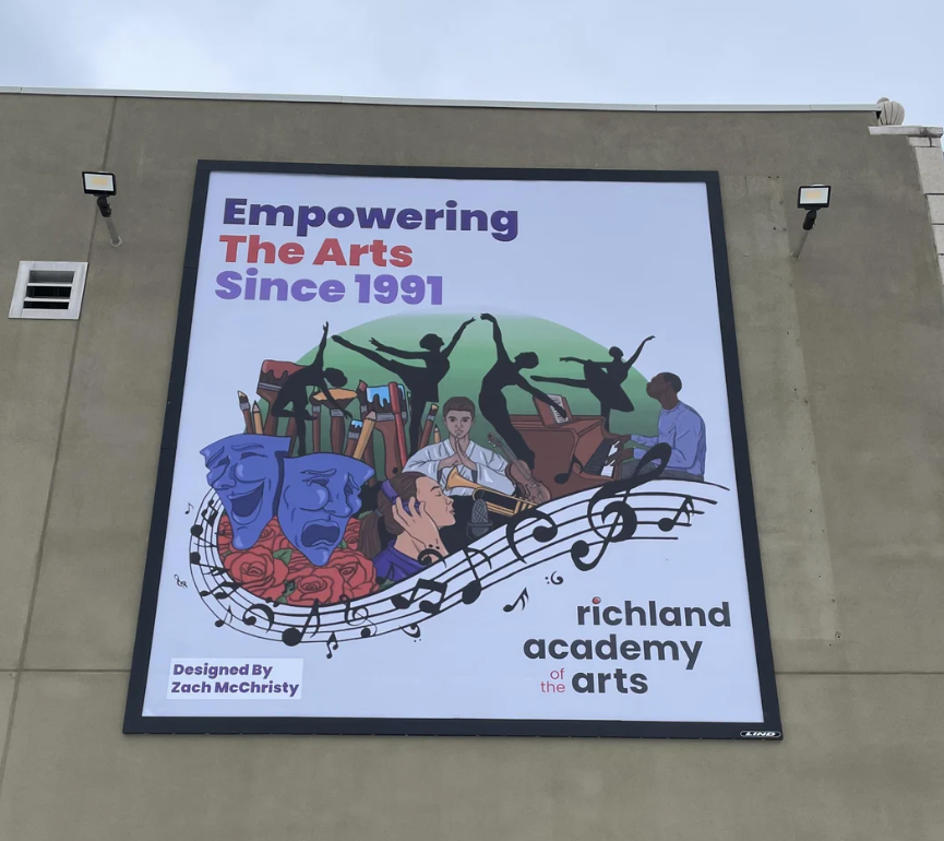 A large outdoor wall sign featuring colorful artwork of dancers, musicians, theater masks, and decorative text.