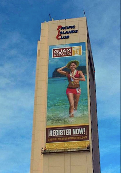 A Lind SignSpring Product – BannerFrameCLASSIC With No Covers for the Guam International Marathon on an exterior concrete wall - Vertical Banner