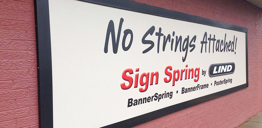 A Lind SignSpring Product – BannerFrameCLASSIC With Covers Sample Display Banner with the wording, “No Strings Attached”.