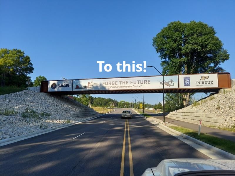 A Lind SignSpring Product – BannerFrameCLASSIC without Covers-Purdue Aerospace District - A long narrow banner attached to a train bridge over a highway–After Photo