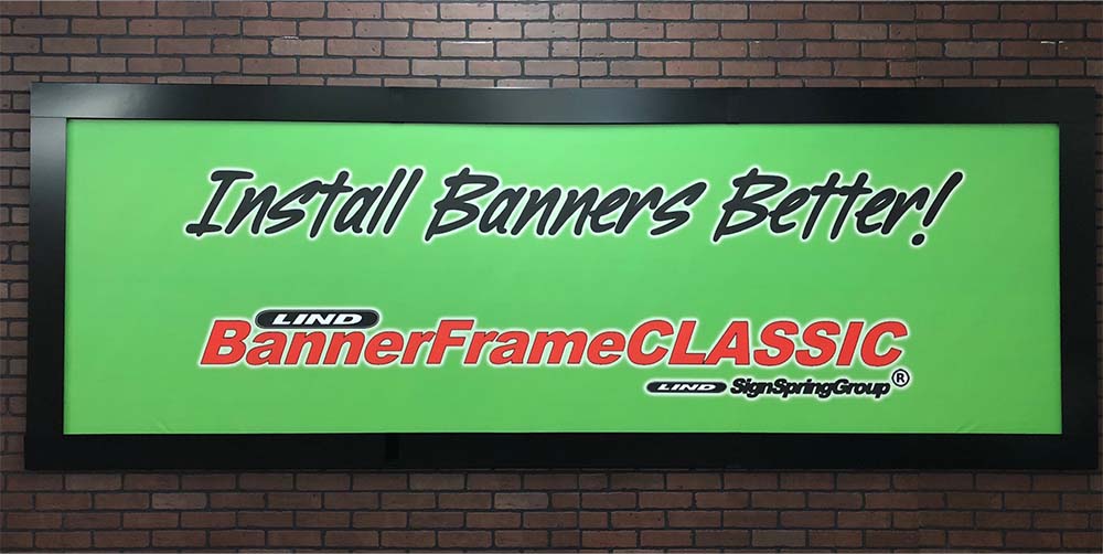 A Lind SignSpring Product – BannerFrameCLASSIC With Covers Sample Display Banner with the wording, “Install Banners Better!”