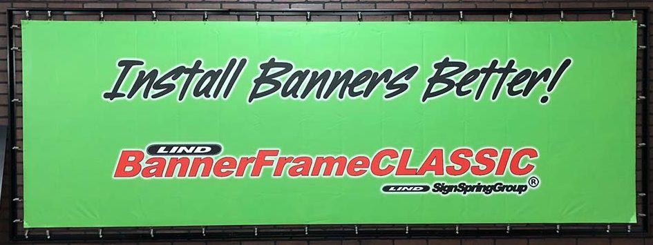 A Lind SignSpring Product – BannerFrameCLASSIC With NO Covers Sample Display Banner with the wording, “Install Banners Better!”