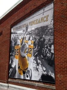 Sports-poster-hung-on-brick-building-222x300 Kickin' Glass and Taking Names! Lind BannerFrame Classic Has Your Retail Signage Covered!
